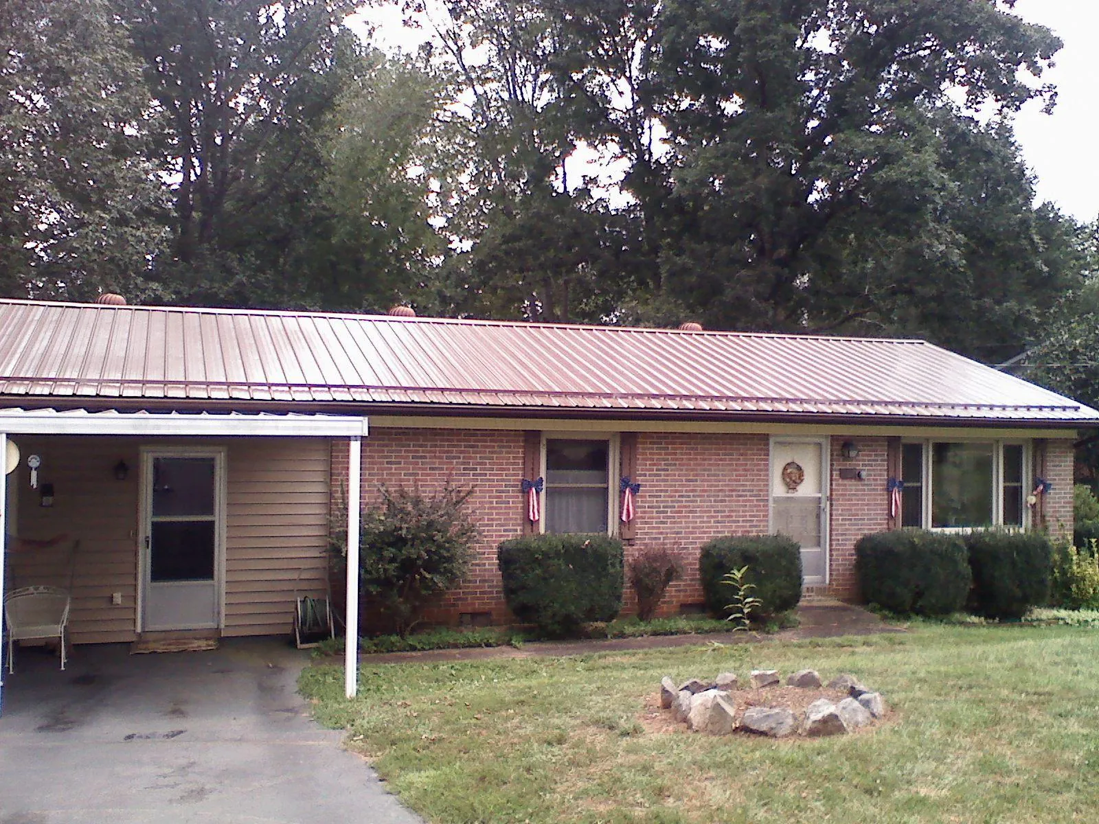 Bronze metal roof and carport on a brick ranch home — Roof Repair work by our crew in Middlebury